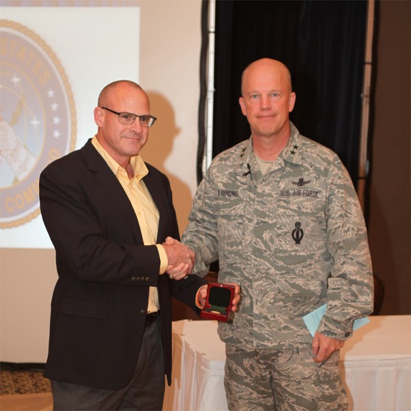 GREATER OMAHA—Kirk Bruno, chapter executive vice president, presents Maj. Gen. John W. Raymond, USAF, director of plans and policy, U.S. Strategic Command, with a chapter coin for presenting at the chapter’s Heartland TechNet luncheon in May.